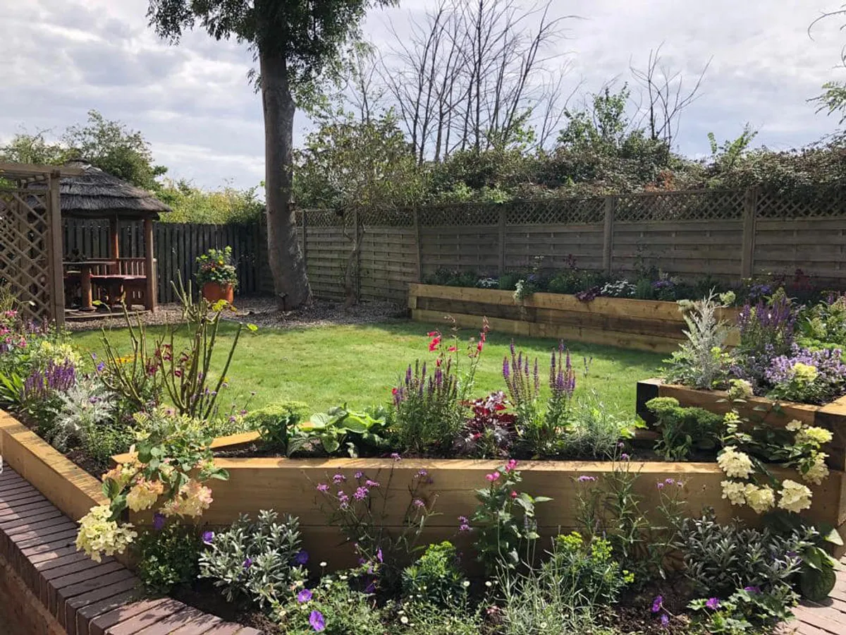 Landscaped Chester garden with lawn, timber raised beds and colourful planting